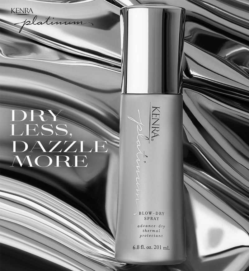 A sleek silver aerosol spray can labeled with the text "Dry Less Dazzle More" displayed against a shiny dark metallic background. Featured image for blog post: Dry Less and Dazzle More with Kenra Platinum Blow-dry Spray