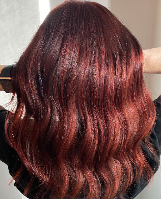Back view of a model's short, chin-length bob in a deep red-burgundy shade with a subtle wave and high-gloss shine. Featured image for blog post: 6 Ways to Rock Red with Kenra Color